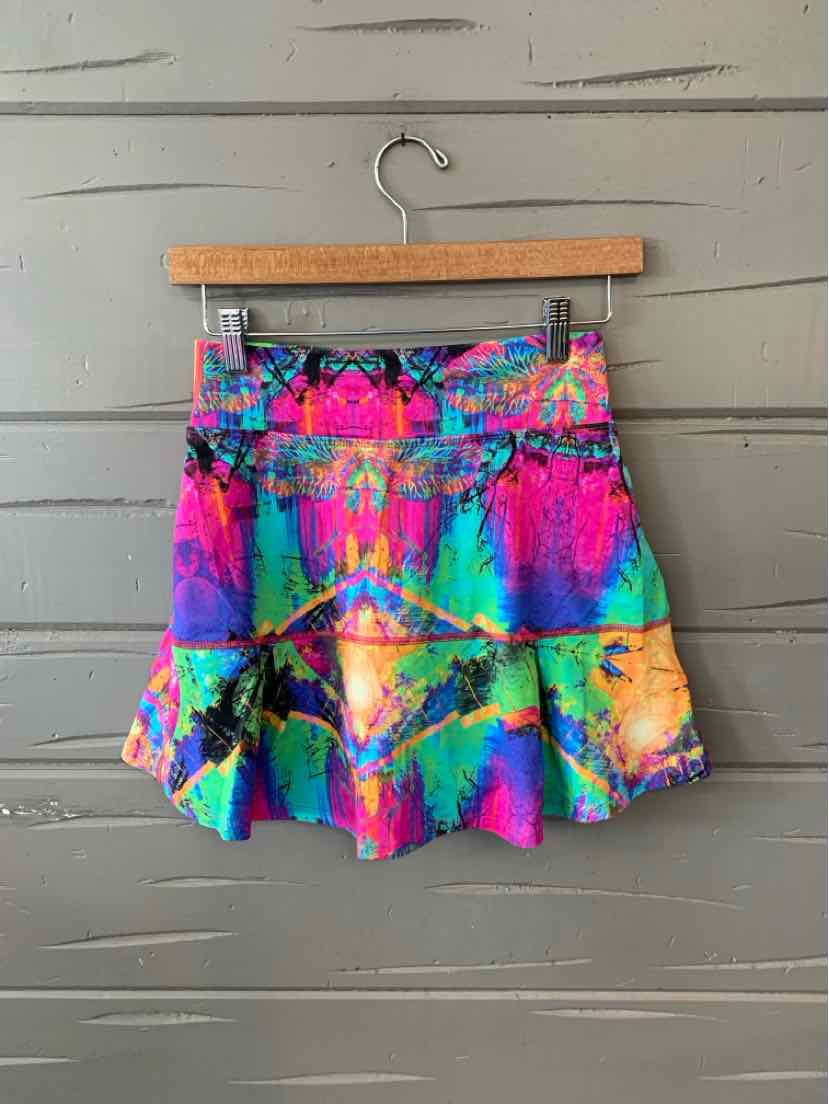 Colorful abstract pattern skirt with vibrant pink, blue, yellow, and green hues on a pleated design.
