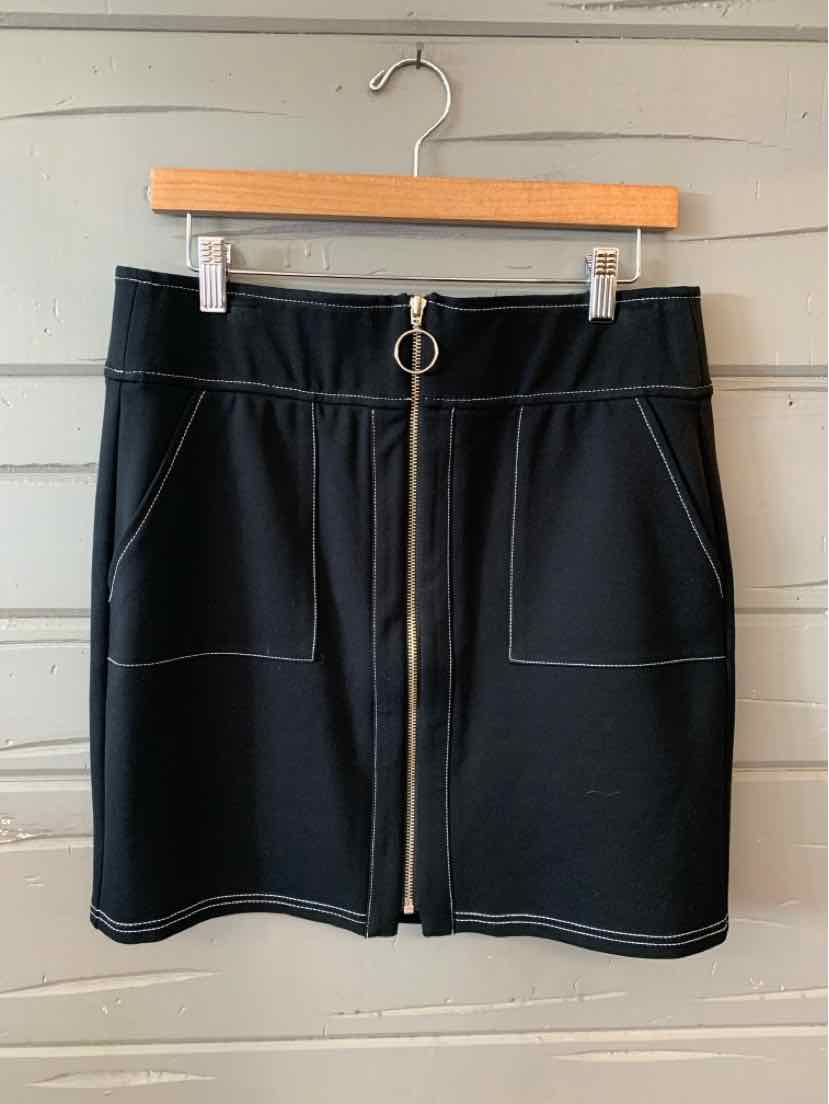 Black mini skirt with front zipper and large patch pockets, featuring contrast stitching details.