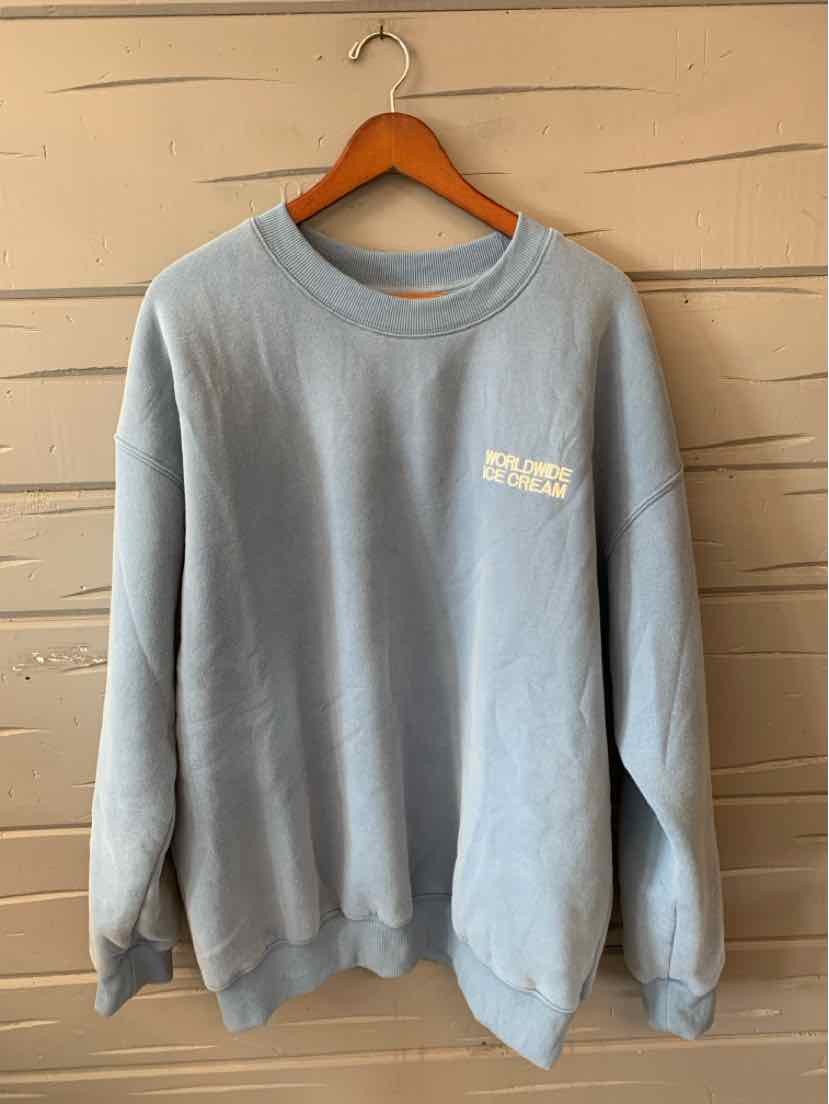 Light blue oversized sweatshirt with crew neck and small white printed logo on chest, size XL.
