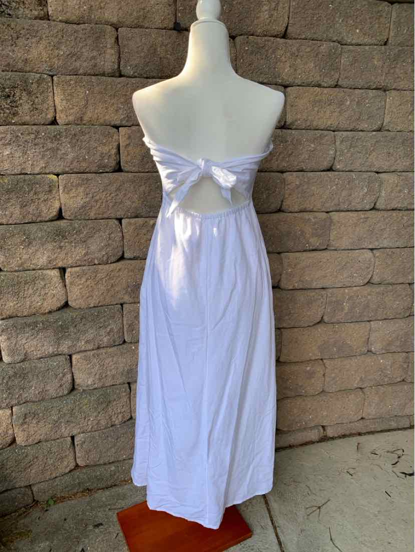White sleeveless maxi dress with open back and bow tie detail below the shoulder blades.