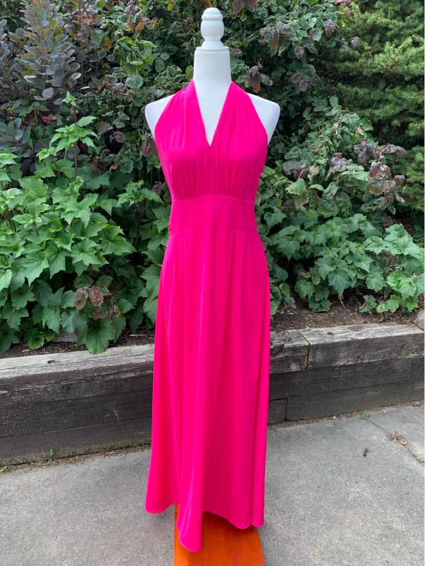Bright pink sleeveless maxi dress with halter neckline and fitted waist.