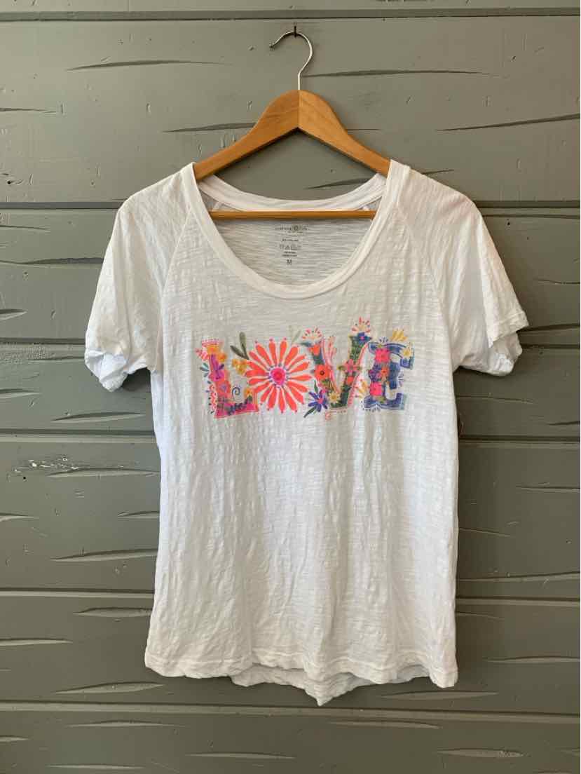White short-sleeve cotton T-shirt with colorful "LOVE" graphic and floral designs on front.