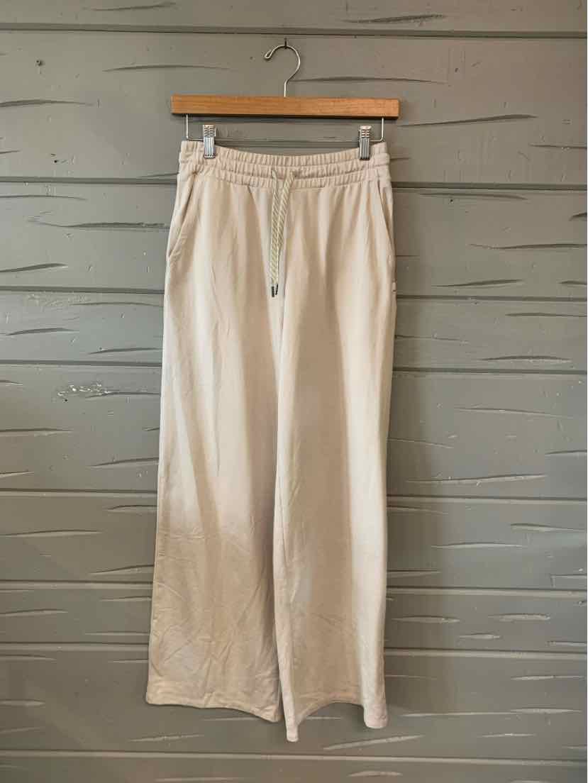 Light beige wide-leg pants with an elastic waistband and drawstring, made from soft fabric.