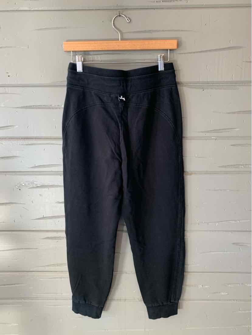 Black women’s jogger pants with an elastic waistband, drawstring, side pockets, and gathered cuffs.