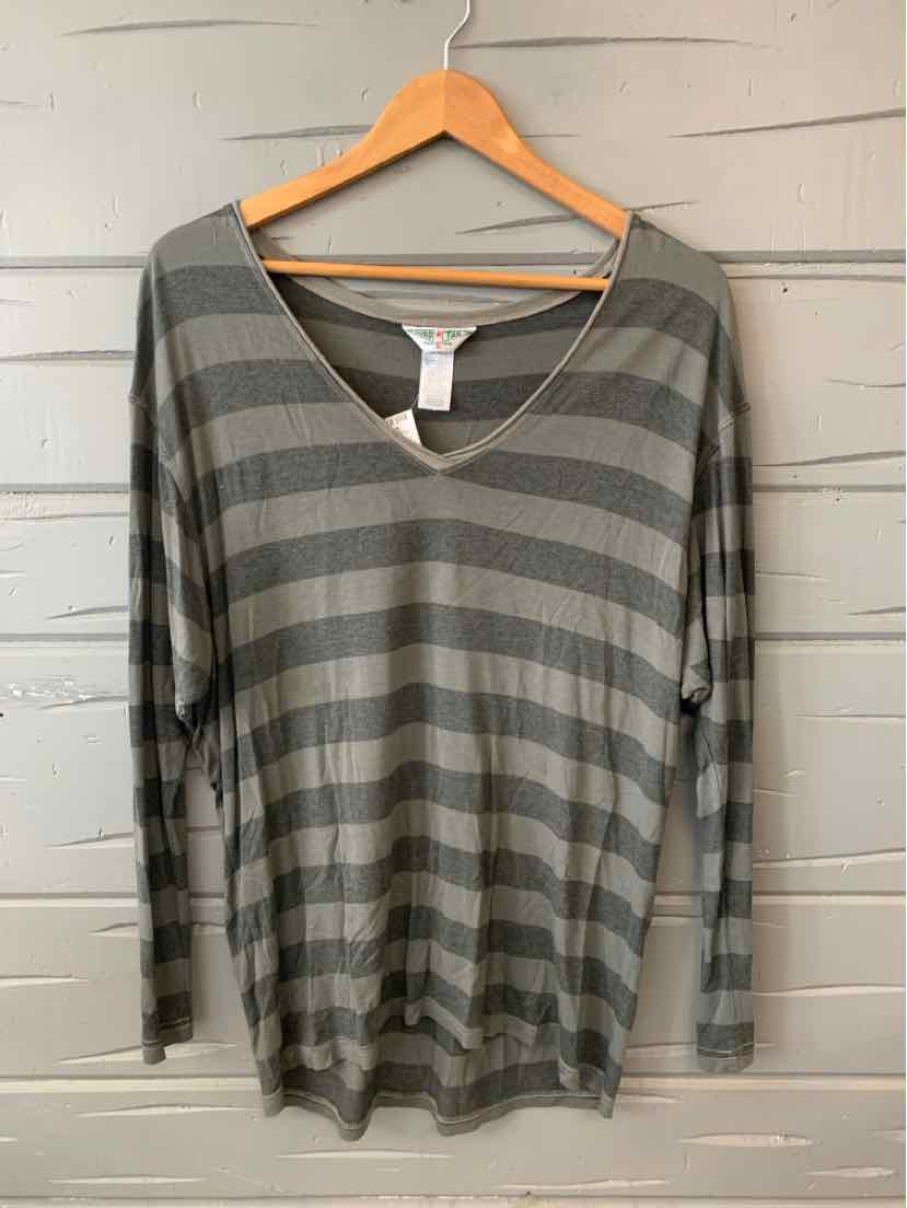 Gray and olive green striped long-sleeve v-neck shirt hanging on wooden hanger against gray wooden wall.