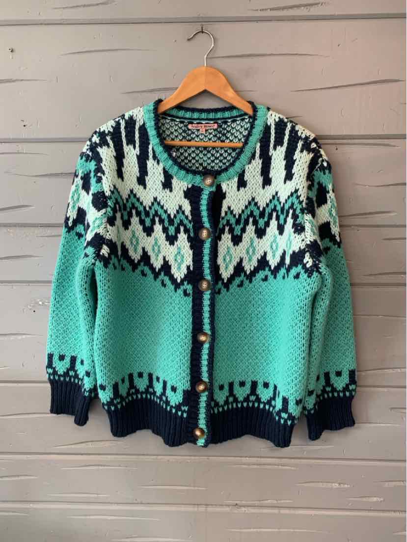 Teal Fair Isle knit cardigan with black and cream geometric patterns, dark trim, and front buttons.