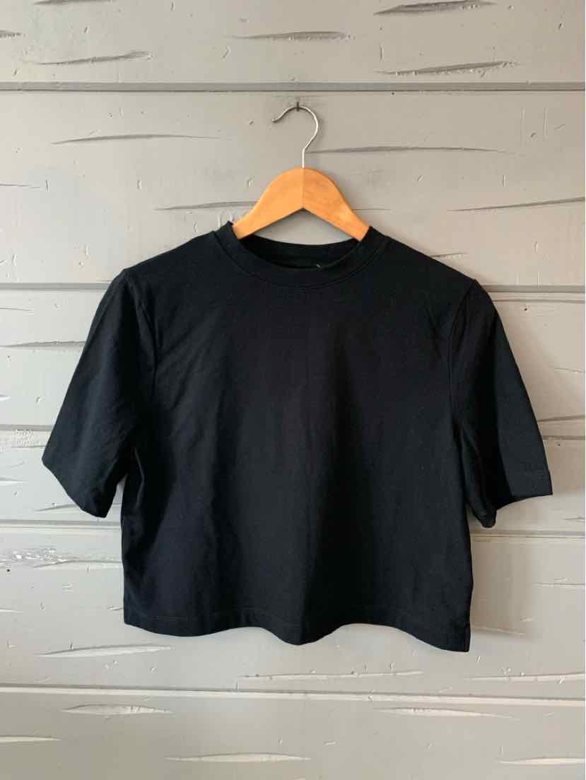 Black short-sleeve crew neck t-shirt with a relaxed fit on a wooden hanger.