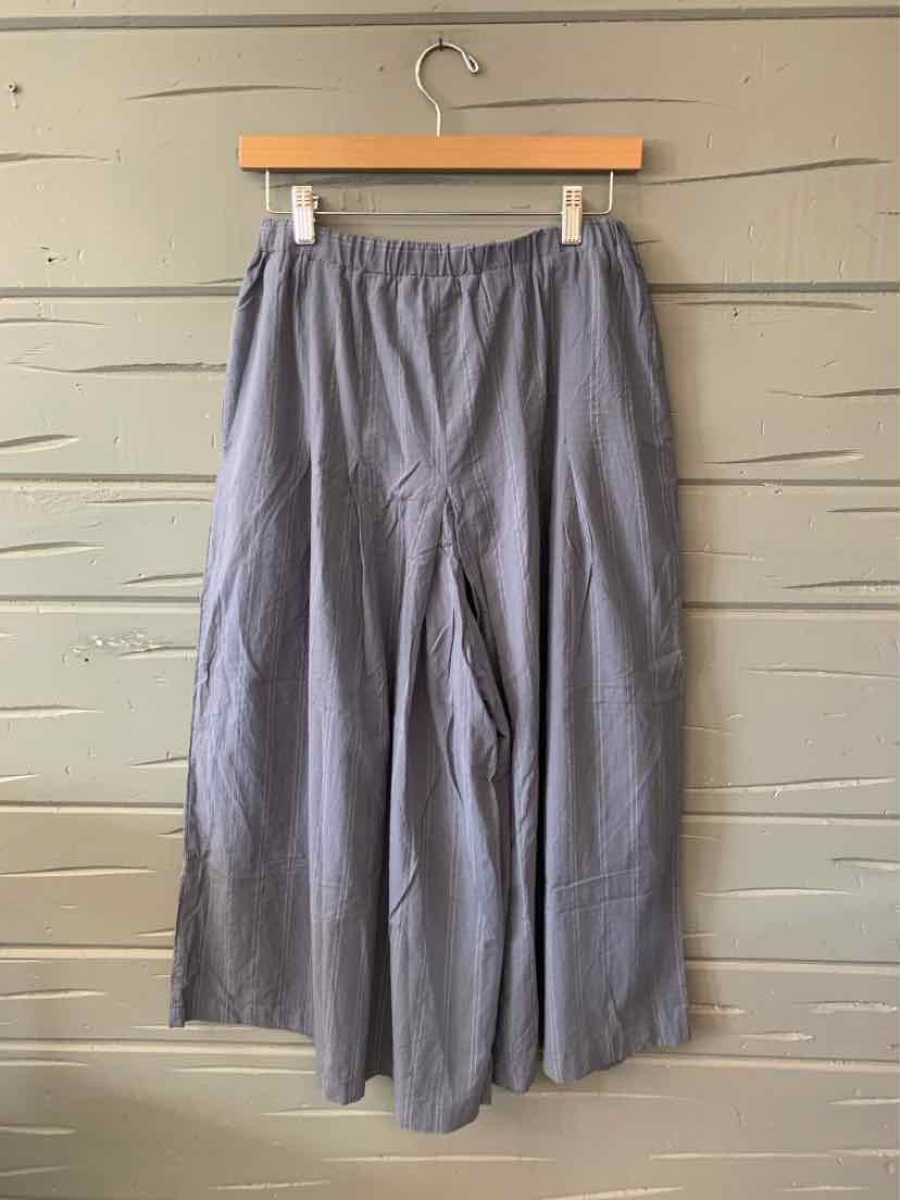 Blue wide-leg pants with an elastic waistband and subtle vertical stripes, hanging on a wooden hanger.