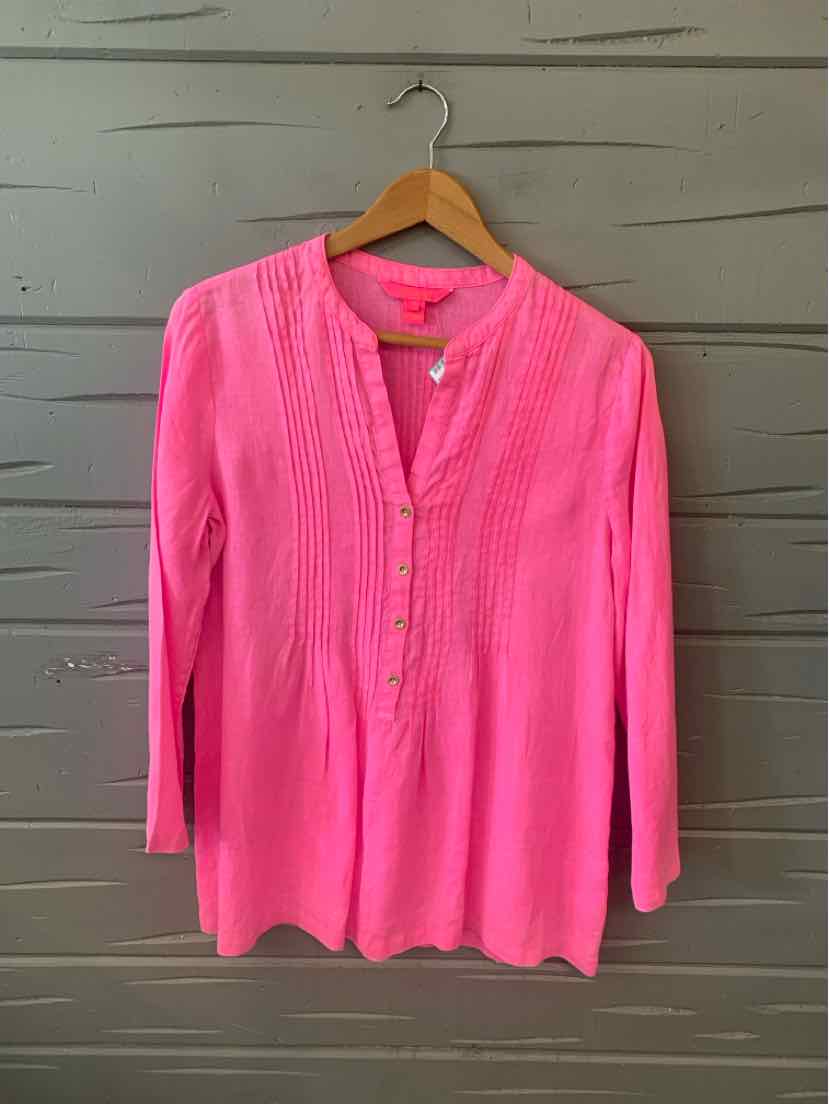 Bright pink long-sleeve blouse with front button placket and pintuck detailing on a wooden hanger.