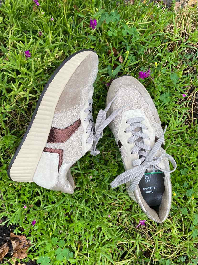 Beige low-top sneakers with textured suede and mesh panels, white laces, and thick ridged rubber soles.