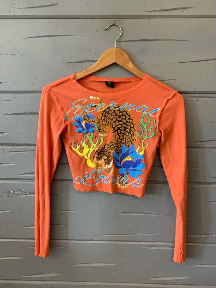 Orange long-sleeve cropped top with colorful graphic featuring a dragon and floral designs.