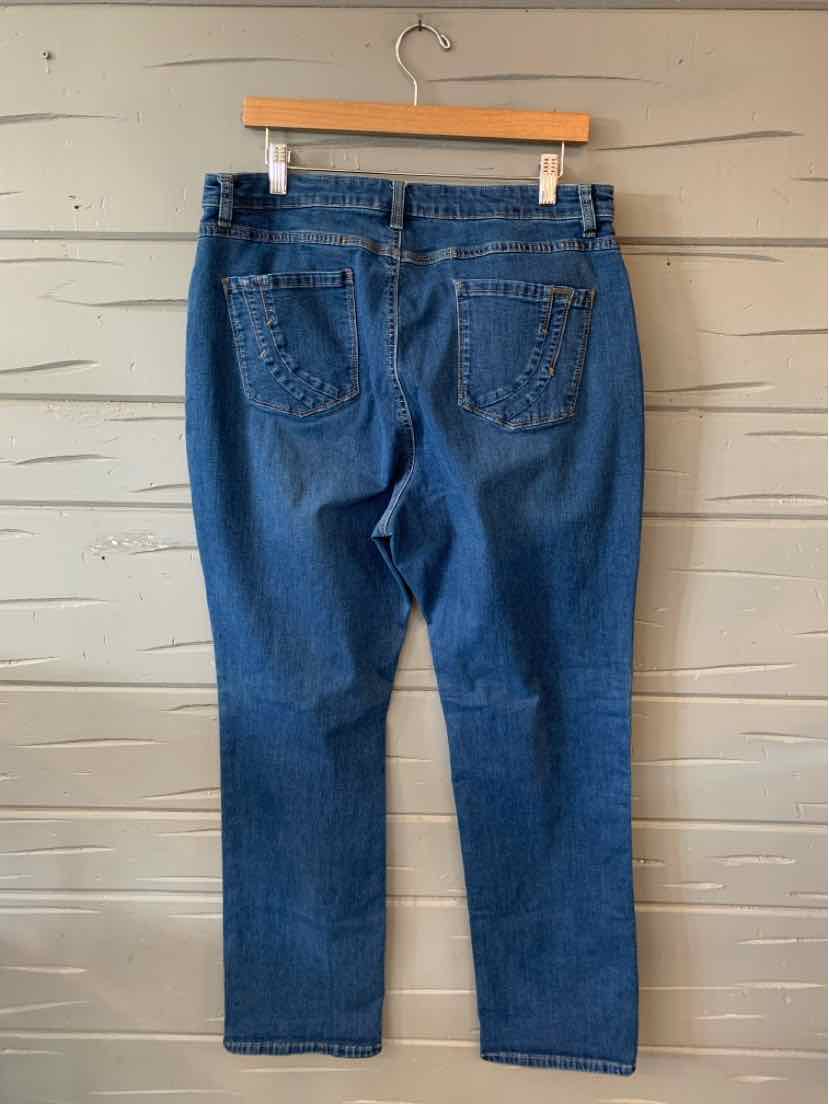 Blue denim jeans with a straight-leg cut and five-pocket design hanging on a wooden hanger against a gray wooden wall.
