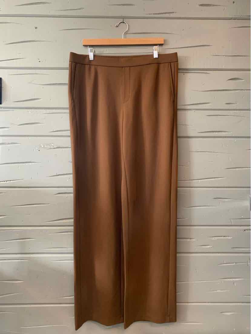Brown wide-leg trousers with a smooth texture and elastic waistband hanging on a wooden hanger.