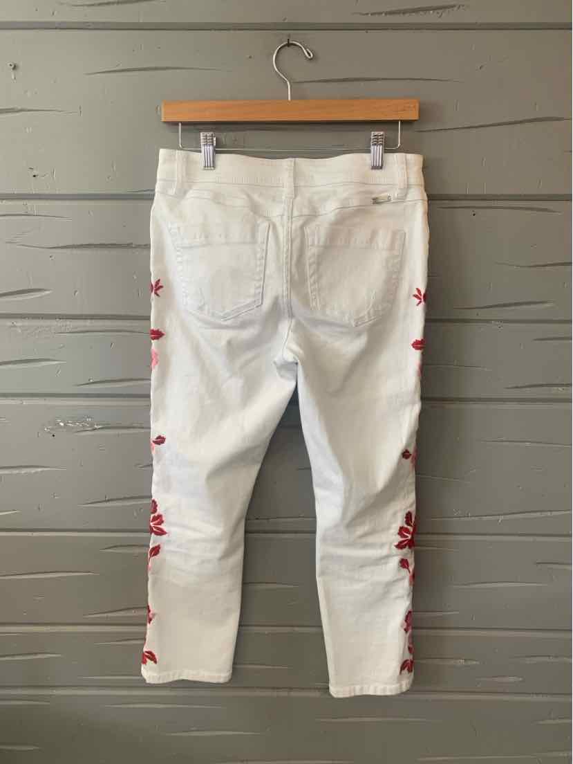 White cropped jeans with red floral embroidery along the outer legs and back pockets.