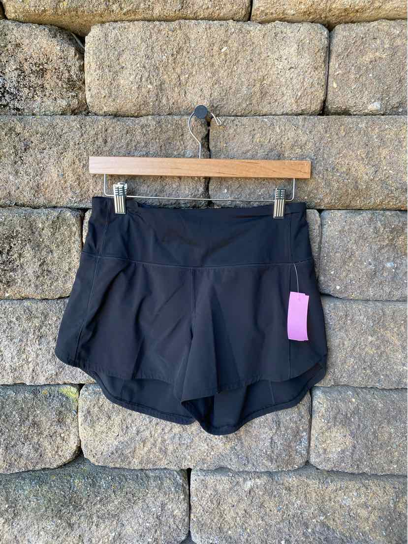 Black athletic shorts with layered fabric design and curved hem, size 6, lightweight material.