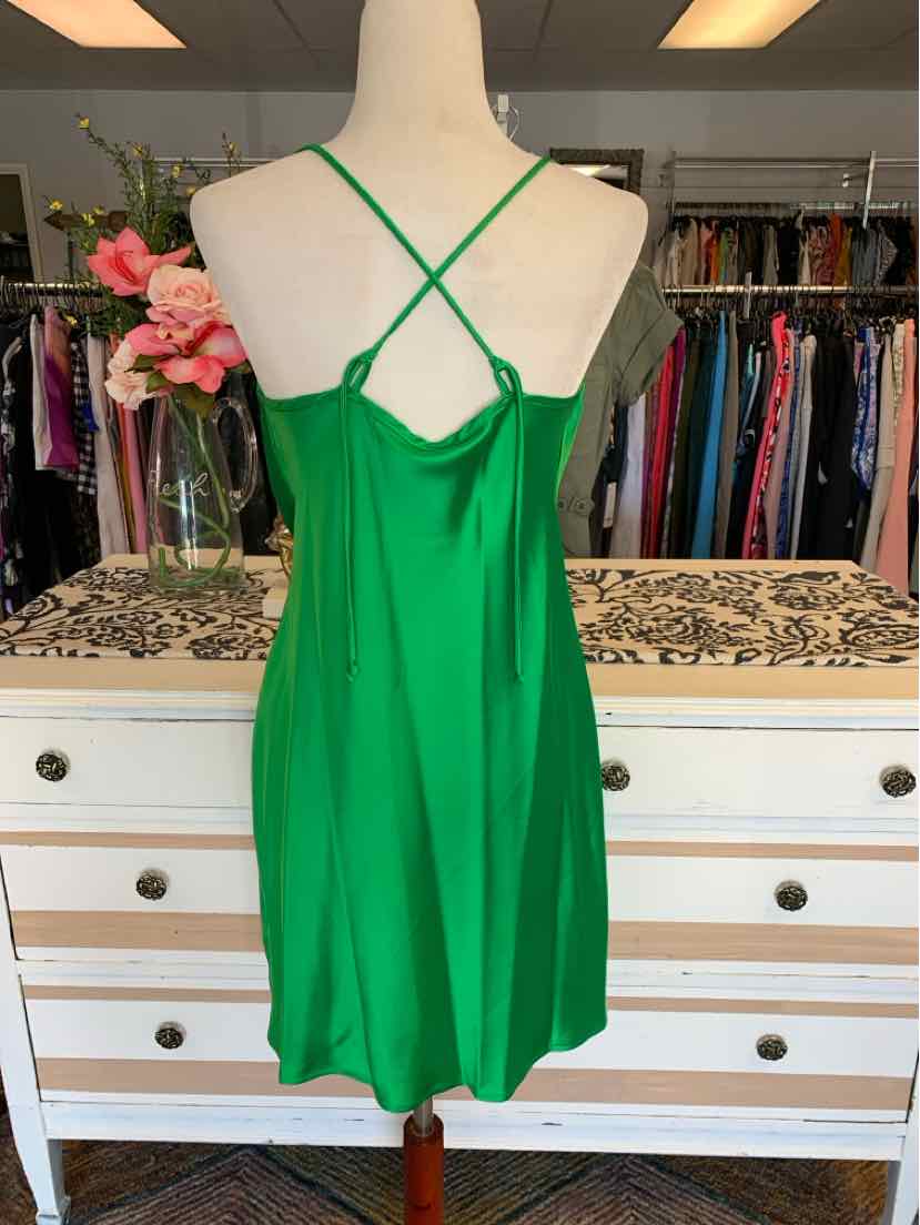 Green satin slip dress with thin crisscross straps and a slight sheen, size medium.