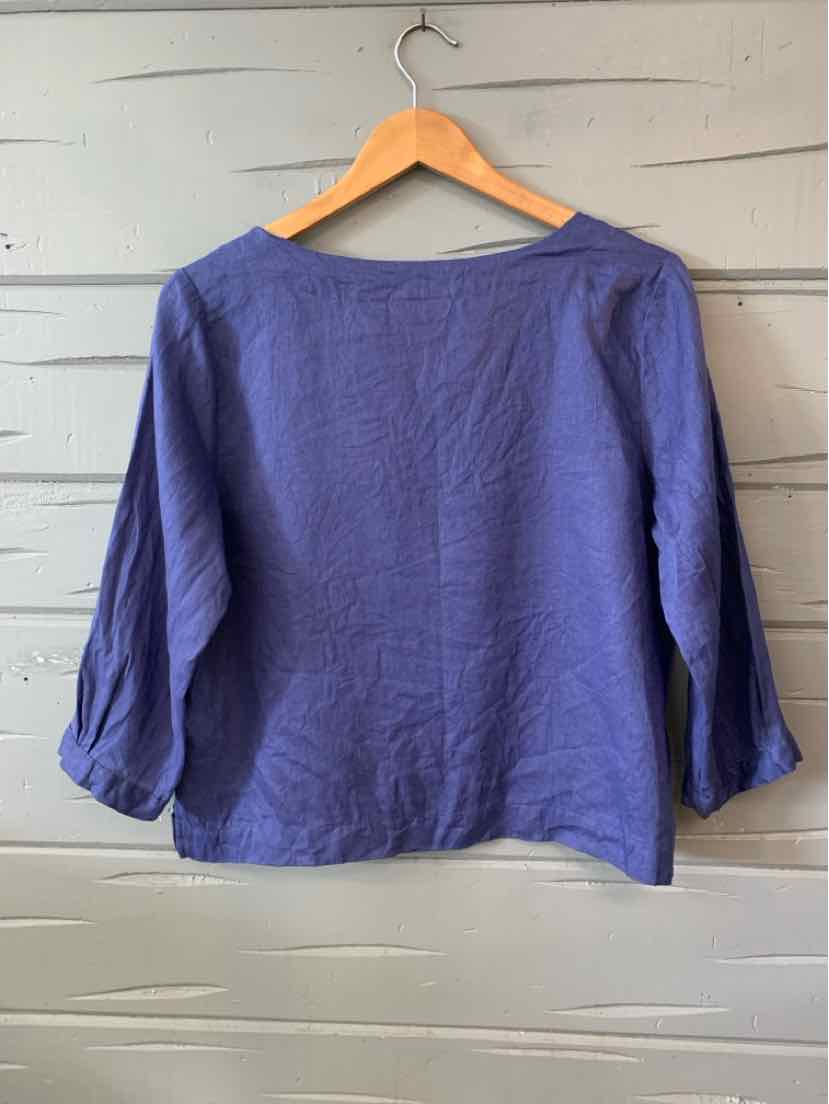Solid medium blue linen blouse with three-quarter puff sleeves and a wide boat neckline.