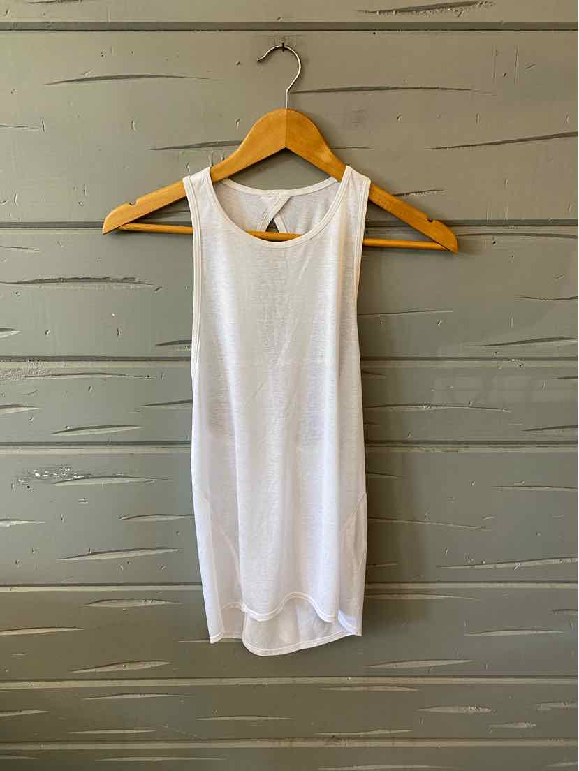 White sleeveless athletic tank top with crew neck and rounded hem hanging on wooden hanger.