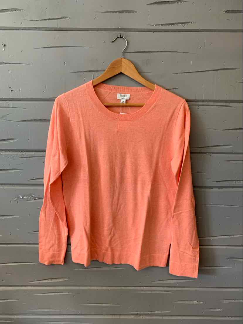 Coral long-sleeve lightweight knit sweater with crew neckline and relaxed fit on wooden hanger.