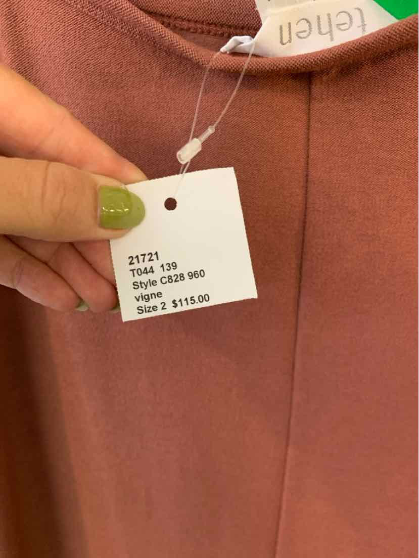 Mauve solid fabric garment with visible stitching and a white brand tag reading "tehen".