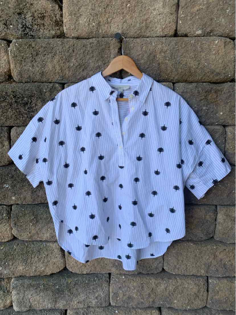 White short-sleeve blouse with black polka dots, loose fit, button-down front, and mandarin collar.