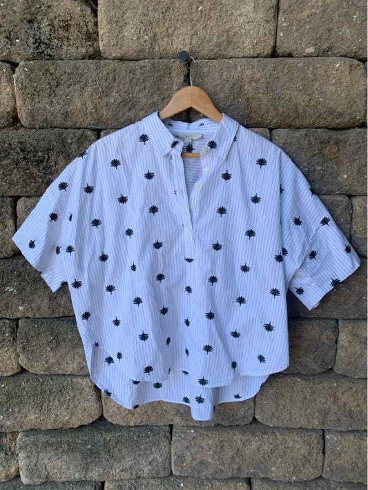 White short-sleeve blouse with black polka dots, loose fit, button-down front, and mandarin collar.