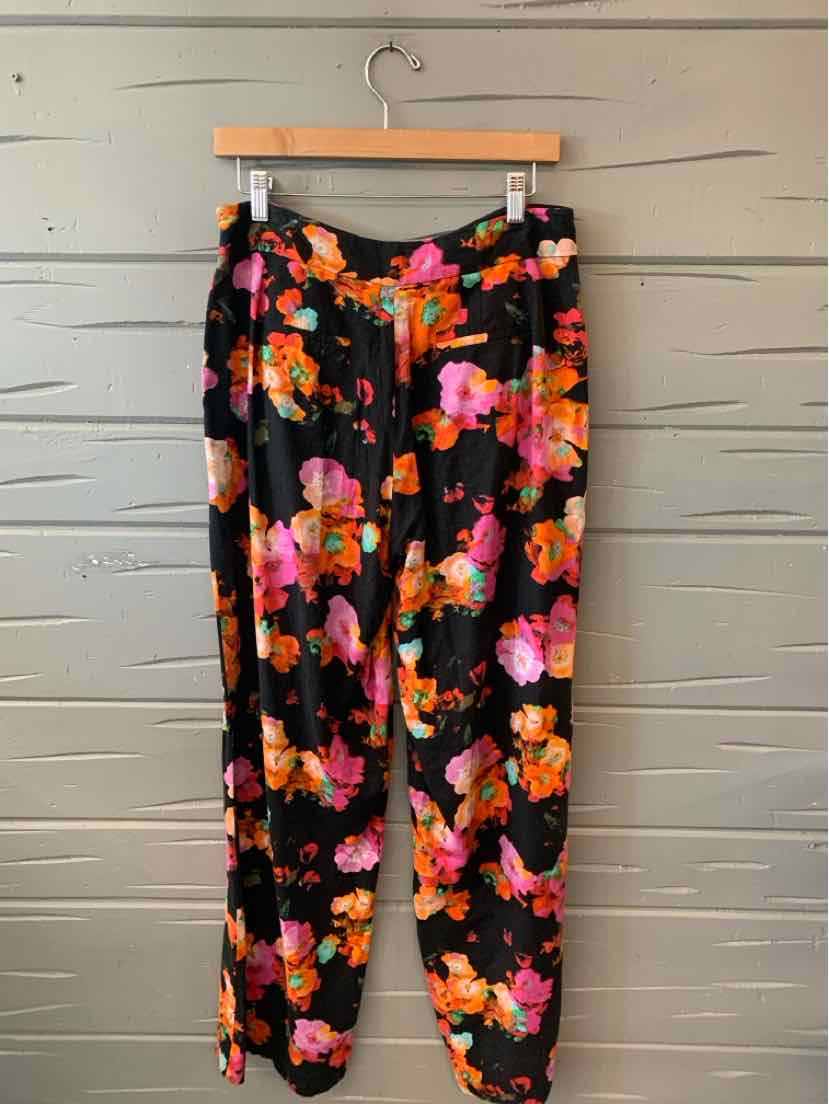 Black tapered pants with vibrant pink, orange, and purple floral print and an elastic waistband.