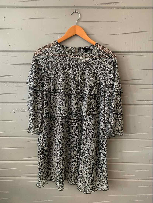 Black and white floral print dress with three-quarter sleeves and relaxed fit on wooden hanger.