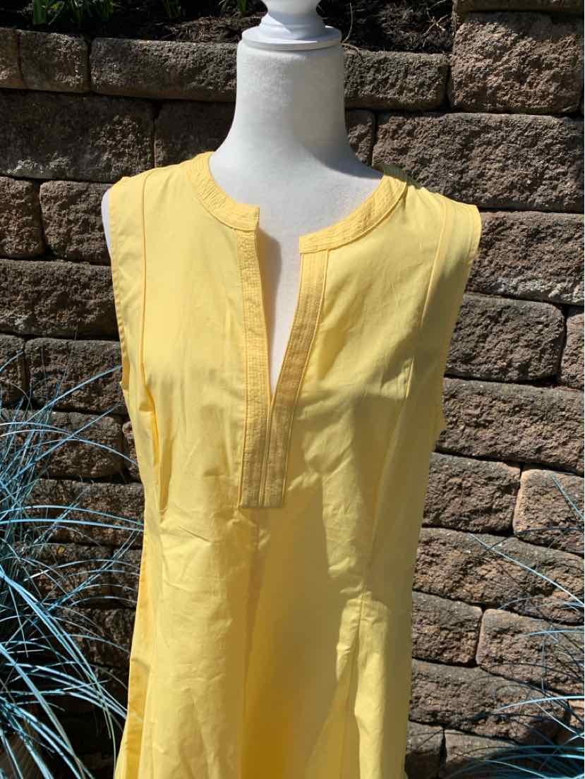 Sleeveless yellow blouse with split neckline and subtle vertical seam details.