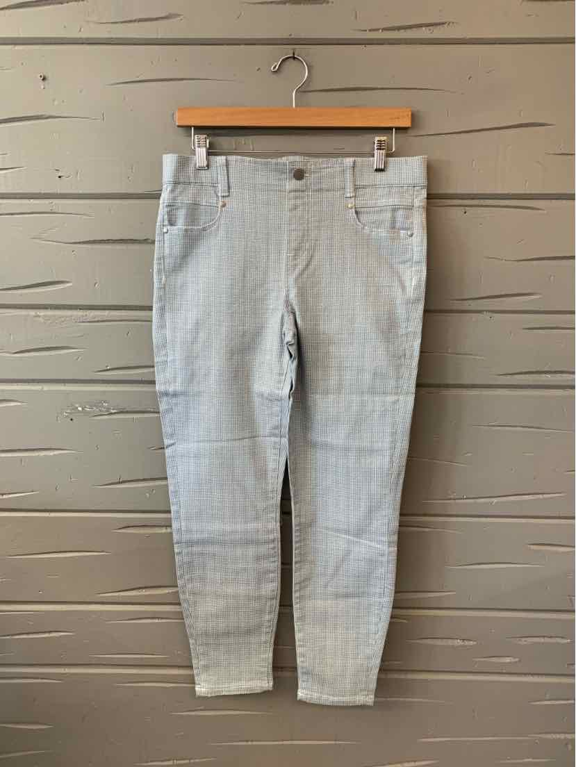 Light gray houndstooth slim-fit pants with front pockets and belt loops hanging on wooden hanger.