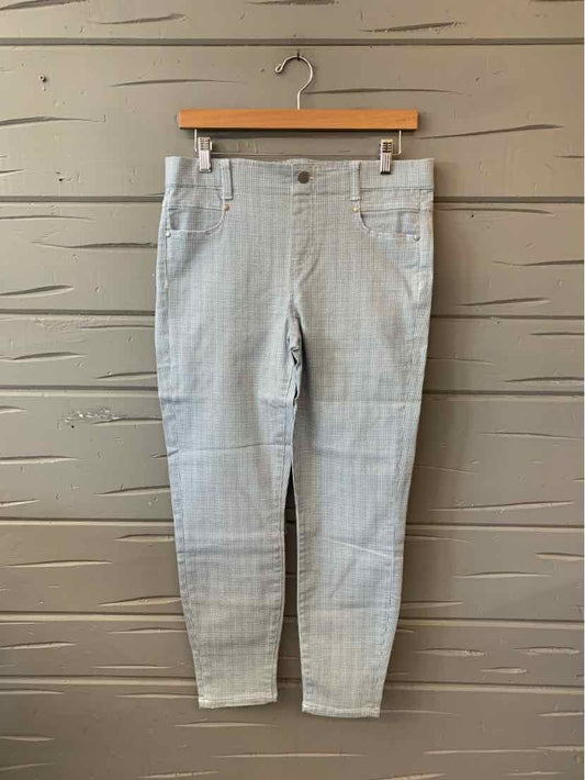 Light gray houndstooth slim-fit pants with front pockets and belt loops hanging on wooden hanger.
