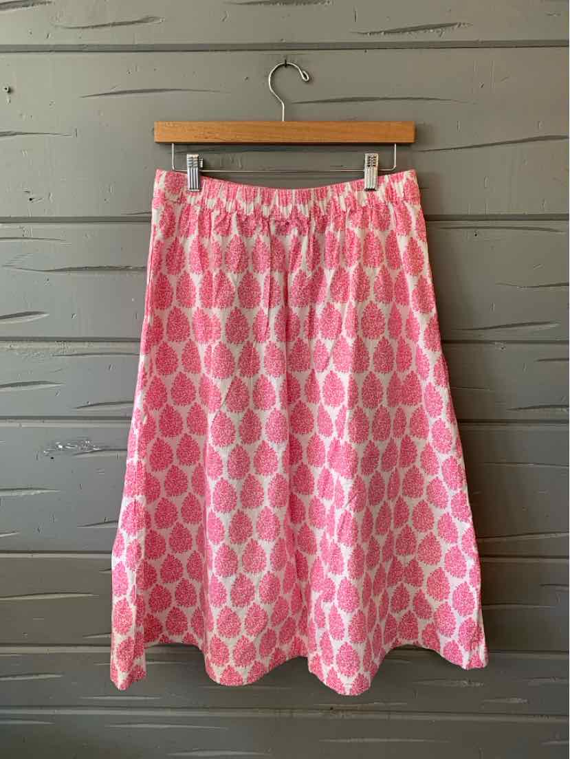 Pink A-line skirt with a repeating circular pattern in lighter pink, midi length, gathered waistband.