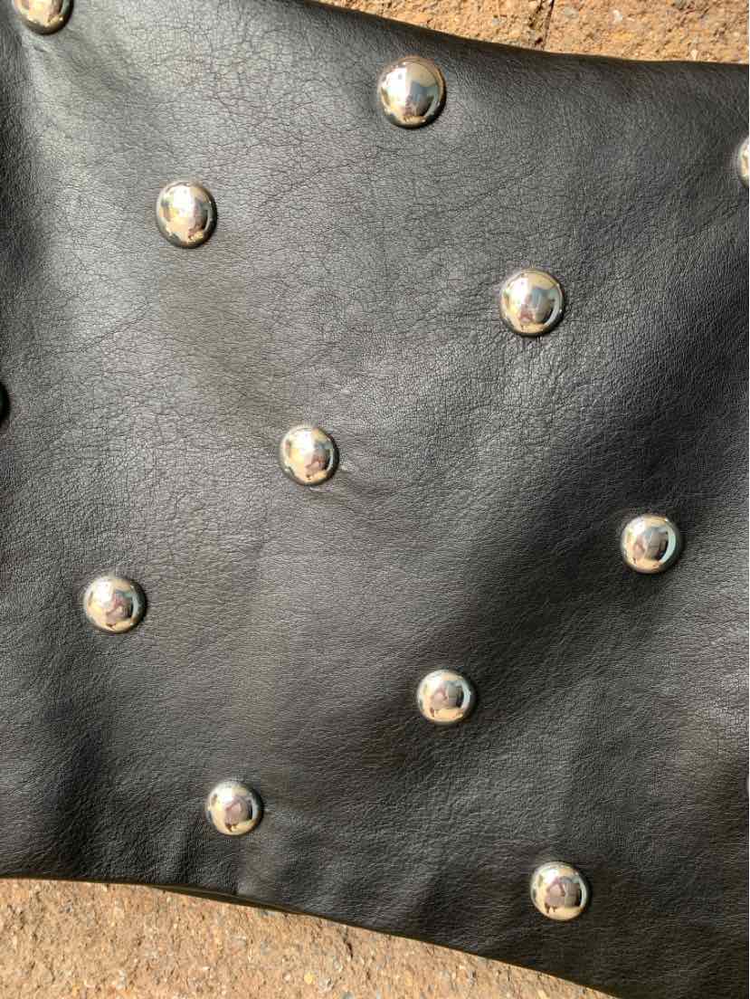 Black leather fabric with evenly spaced round silver studs for decorative detailing.