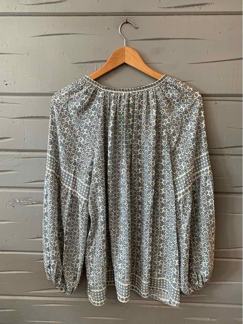Long-sleeve blouse with blue and white floral pattern, gathered neckline, and elastic cuffs.
