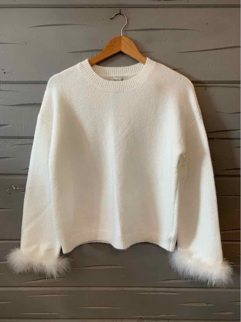 White long-sleeve sweater with round neckline and fluffy feather cuffs, hanging on wooden hanger.