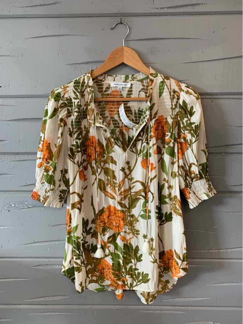 Long-sleeve blouse with orange rose and olive green floral print on cream background, gathered cuffs, and V-neckline.