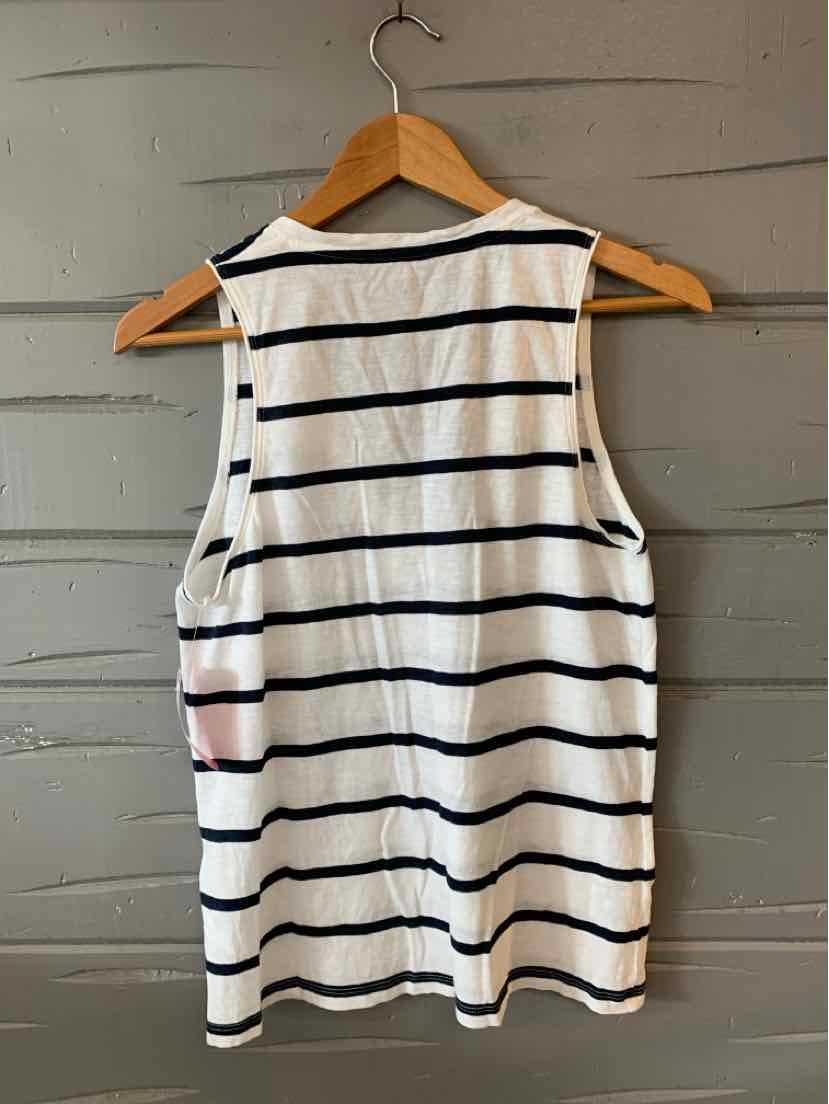 White sleeveless tank top with navy horizontal stripes, hanging on wooden hanger against gray wall.