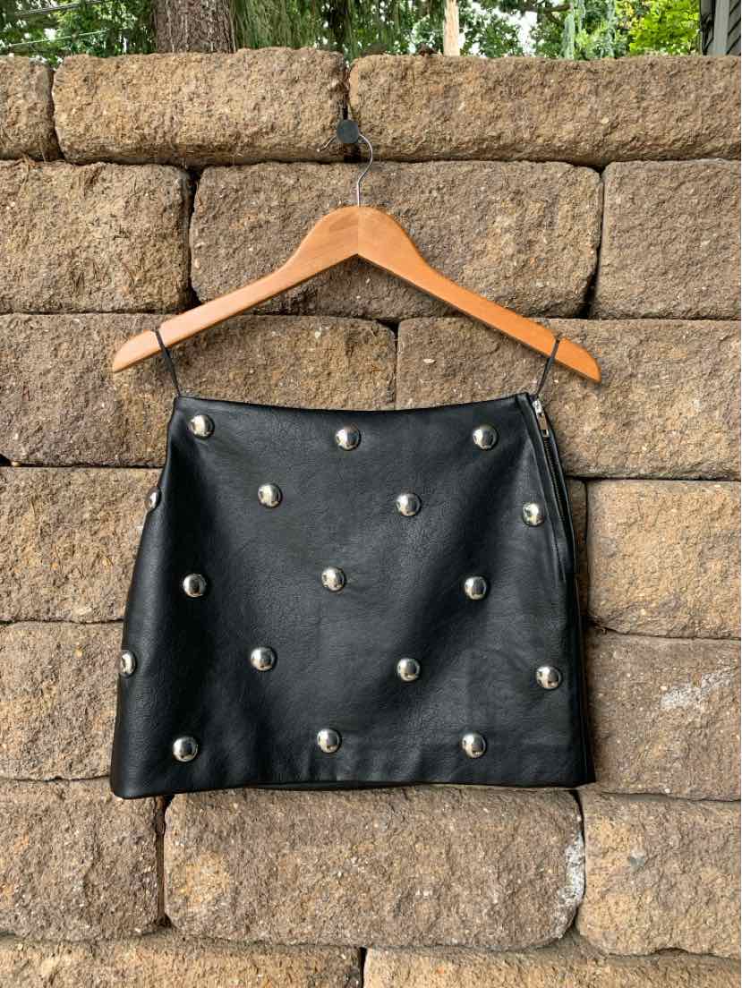 Black leather mini skirt with silver stud embellishments on front and back.