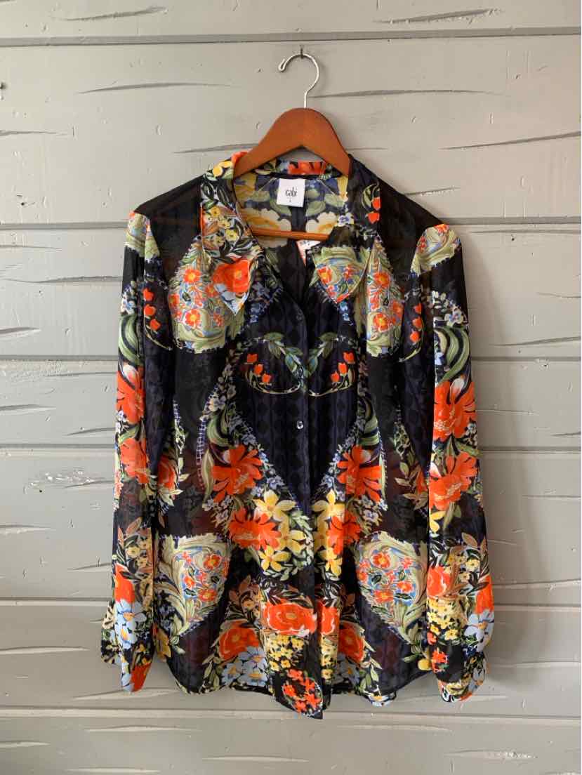 Black long-sleeve blouse with vibrant orange, yellow, and white floral print and button-down front.
