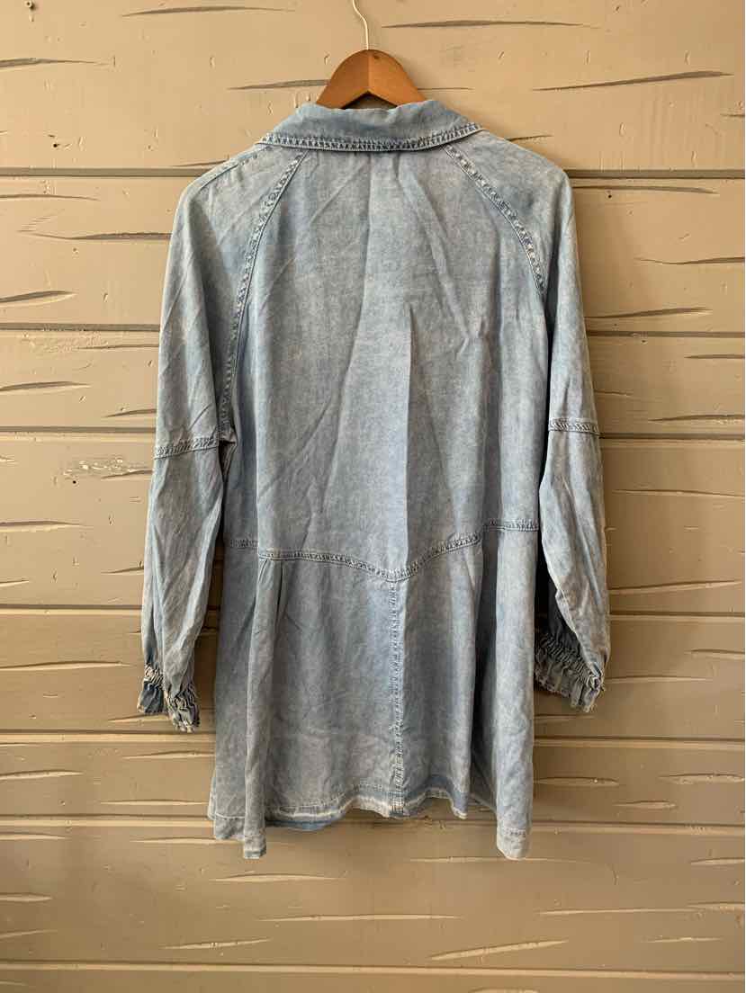 Light blue long-sleeve button-up shirt with a subtle textured pattern and a relaxed fit hanging on a wooden hanger.