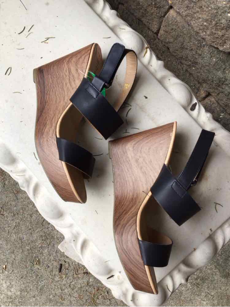 Black leather wedge sandals with wooden textured platform and ankle straps, size 11.