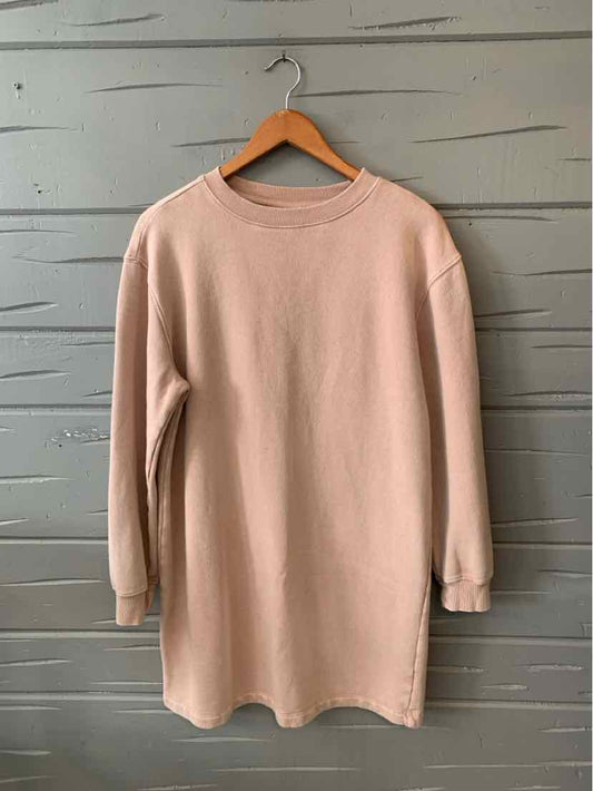 Light beige long-sleeve oversized sweatshirt with crew neckline hanging on wooden hanger.