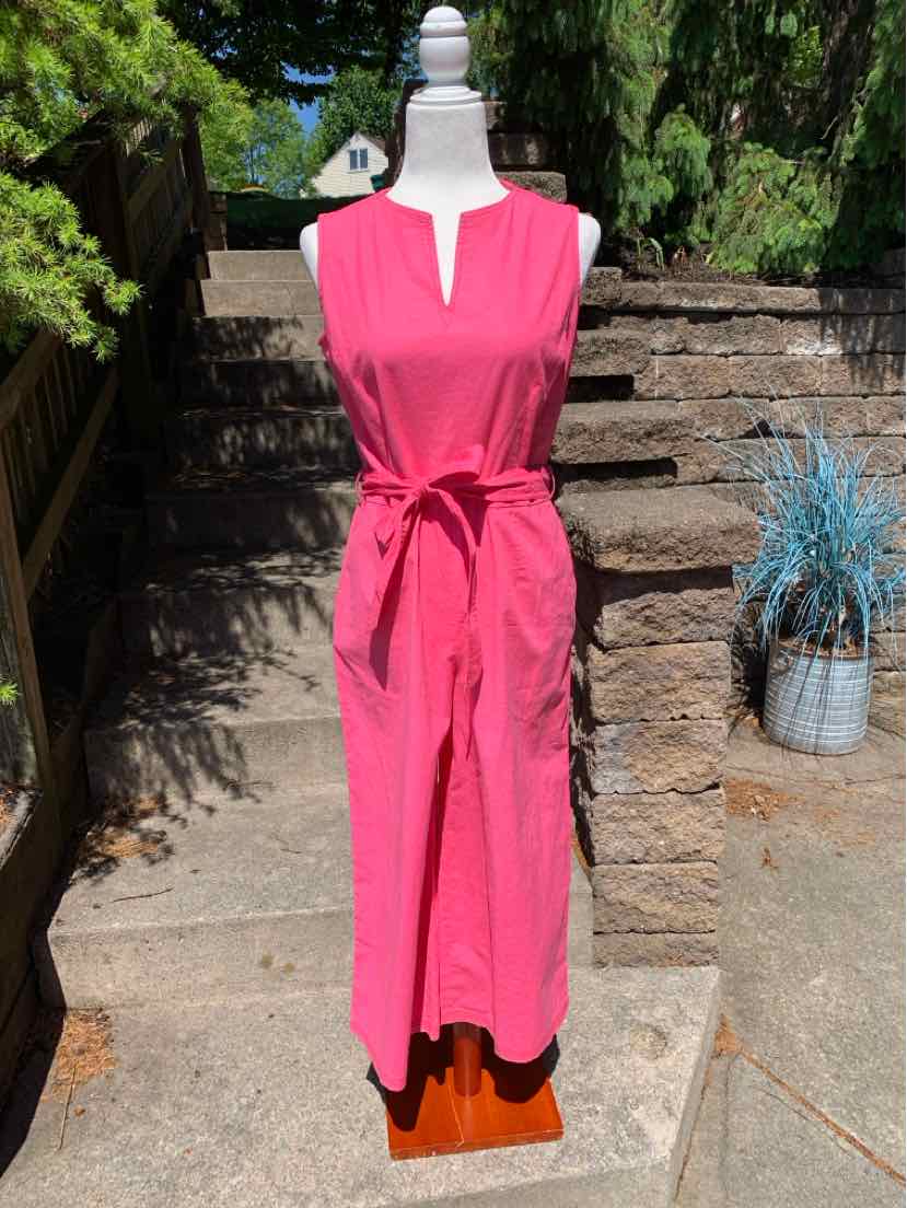 Pink sleeveless midi dress with front slit neckline and waist tie belt on mannequin outdoors.