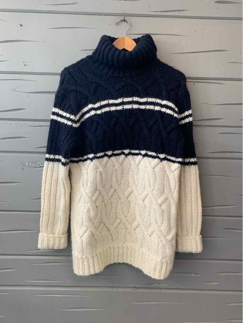 Navy and cream chunky cable-knit sweater with a high ribbed collar and striped yoke.