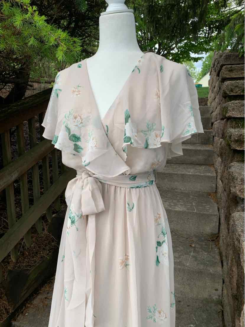 Beige floral wrap dress with flutter sleeves and waist tie on mannequin.