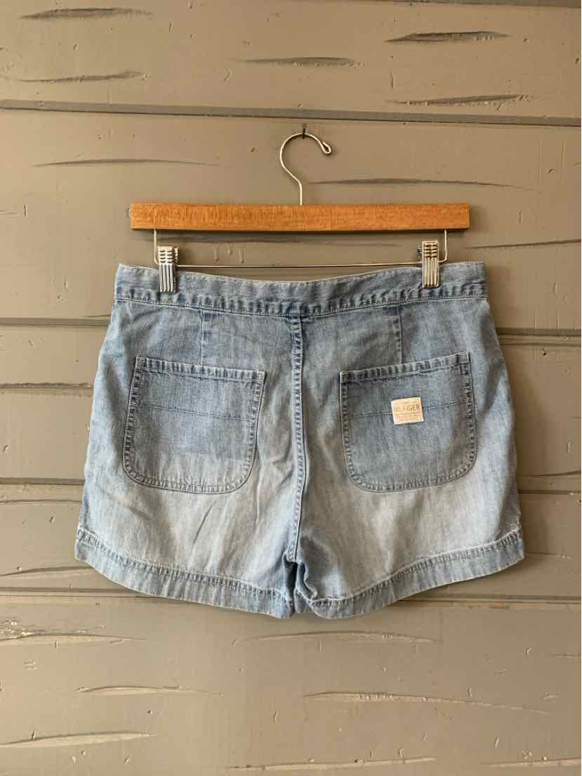 Light blue denim shorts with cuffed hems, two back patch pockets, and a small white brand label on the right pocket.