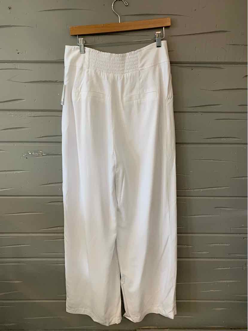 White wide-leg pants with a high waist and clean front, hanging on a wooden hanger.