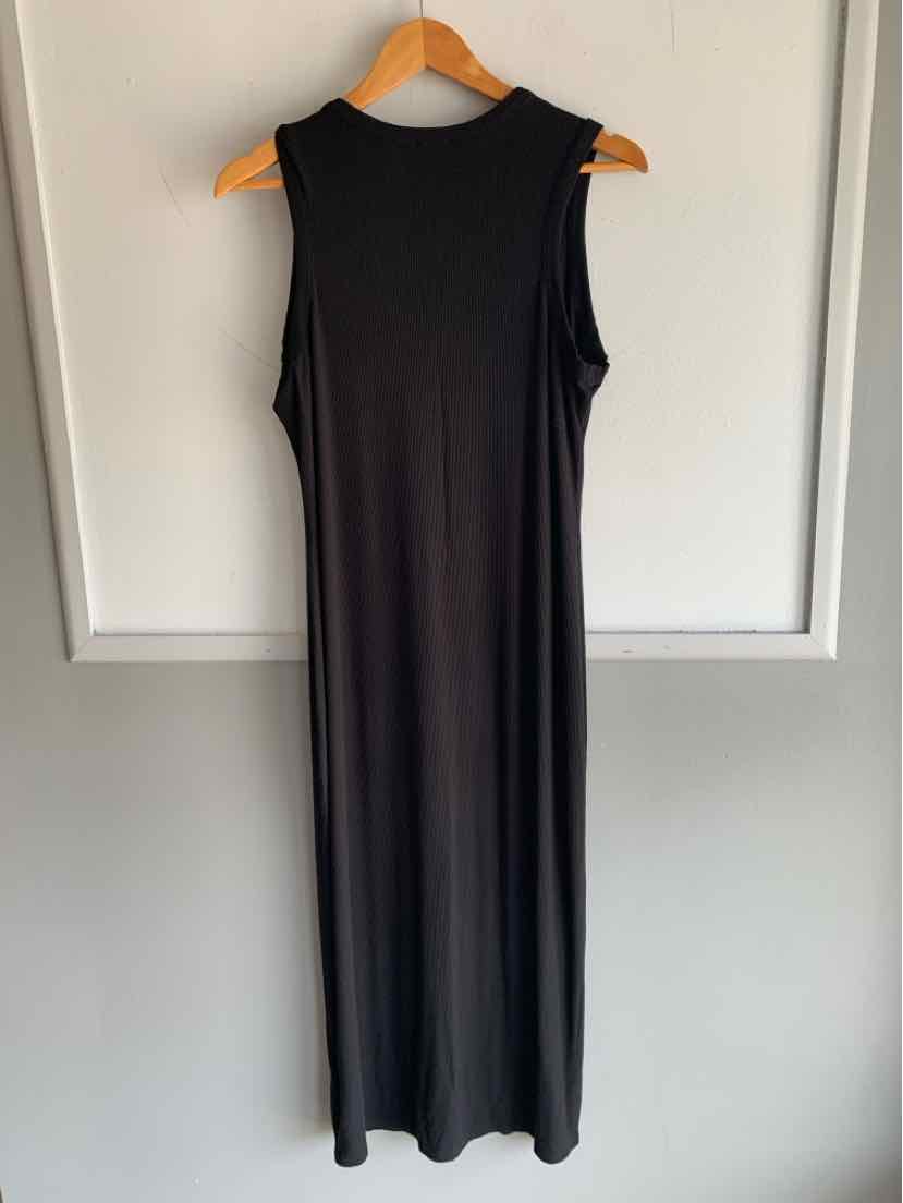 Sleeveless black midi dress with round neckline and straight silhouette hanging on wooden hanger.