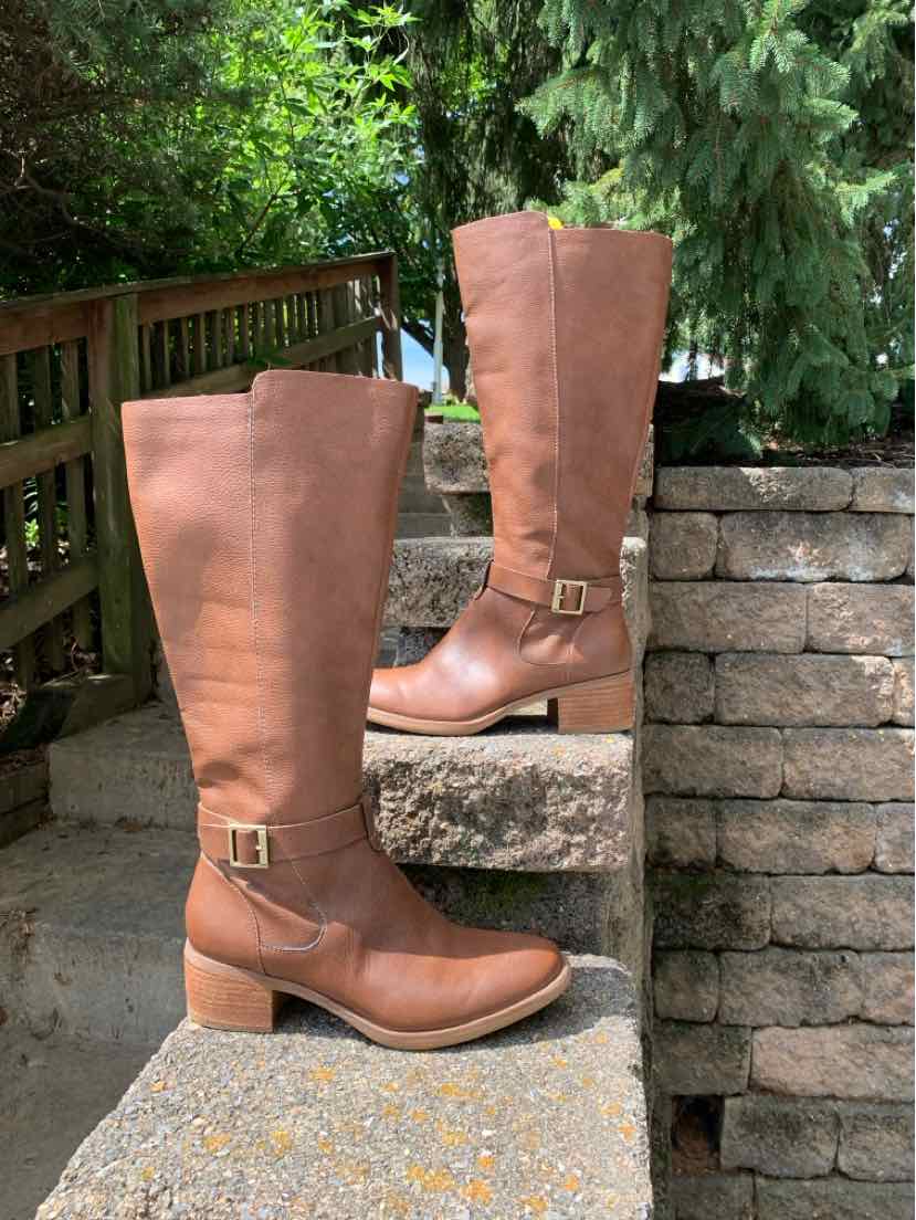 Tan leather mid-calf boots with low block heels and adjustable side buckles.