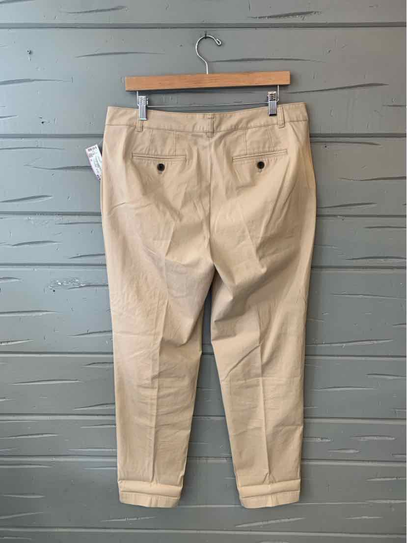 Khaki straight-leg pants with cuffed hems and back button pockets hanging on wooden hanger.